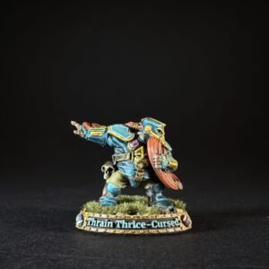 Painted miniature of a dwarf warrior in blue armor with a red beard, holding a shield, standing on a grassy base labeled 'Thrain Thrice-Cursed'.