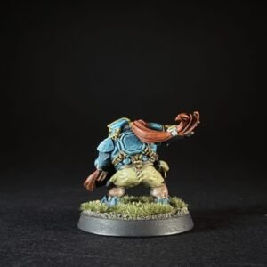 Back view of a blue-armored fantasy miniature with a red scarf, standing on a grassy base.