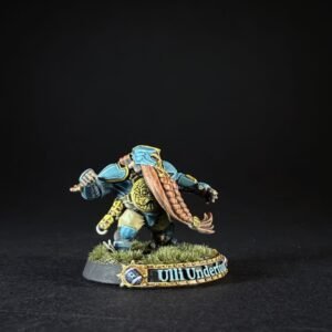 Dwarf miniature in teal armor with an orange braided beard, posed to strike, on a grassy base reading 'Uli Underfoot'.