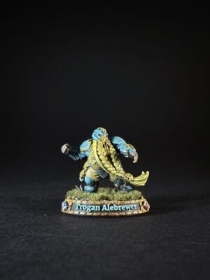 Miniature figure of Trogan Alebrewer, a blue-skinned warrior with gold trim, standing on grassy base.