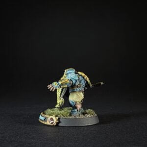 Tabletop miniature of a blue-armored fighter with a long yellow braided ponytail, kneeling on a grassy base.