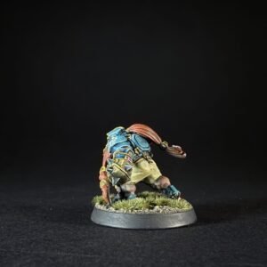 Small painted fantasy miniature of a humanoid turtle in blue armor with red hair on a grassy round base.