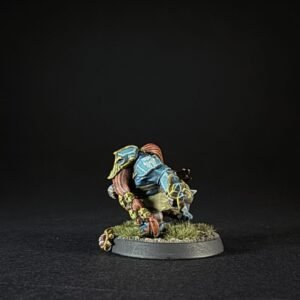 Colorful fantasy miniature figure crouching on a grassy round base, painted blue, yellow, and red with detailed armor pieces.