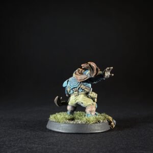 Back-view miniature of a dwarf wearing blue armor and a brown scarf, standing on a grassy round base against a black background.