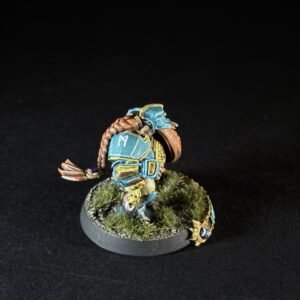 Painted tabletop miniature of a blue armored warrior with a brown braided tail on a mossy circular base.
