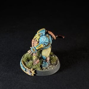 Colorful painted fantasy miniature of a teal-armored warrior standing on a rocky grassy base, viewed from the side.