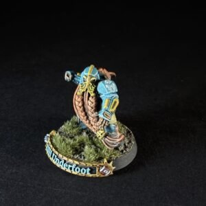 Painted fantasy miniature of a blue-armored warrior with yellow accents, standing on a grassy round base with a banner that reads 'Thunderfoot'.