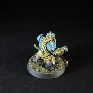 Fantasy miniature warrior in blue and gold armor on a grassy base, holding a curved blade.