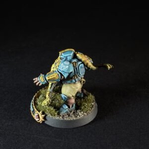 Colorful science-fiction miniatures figure in blue armor lunging forward on a grassy base.