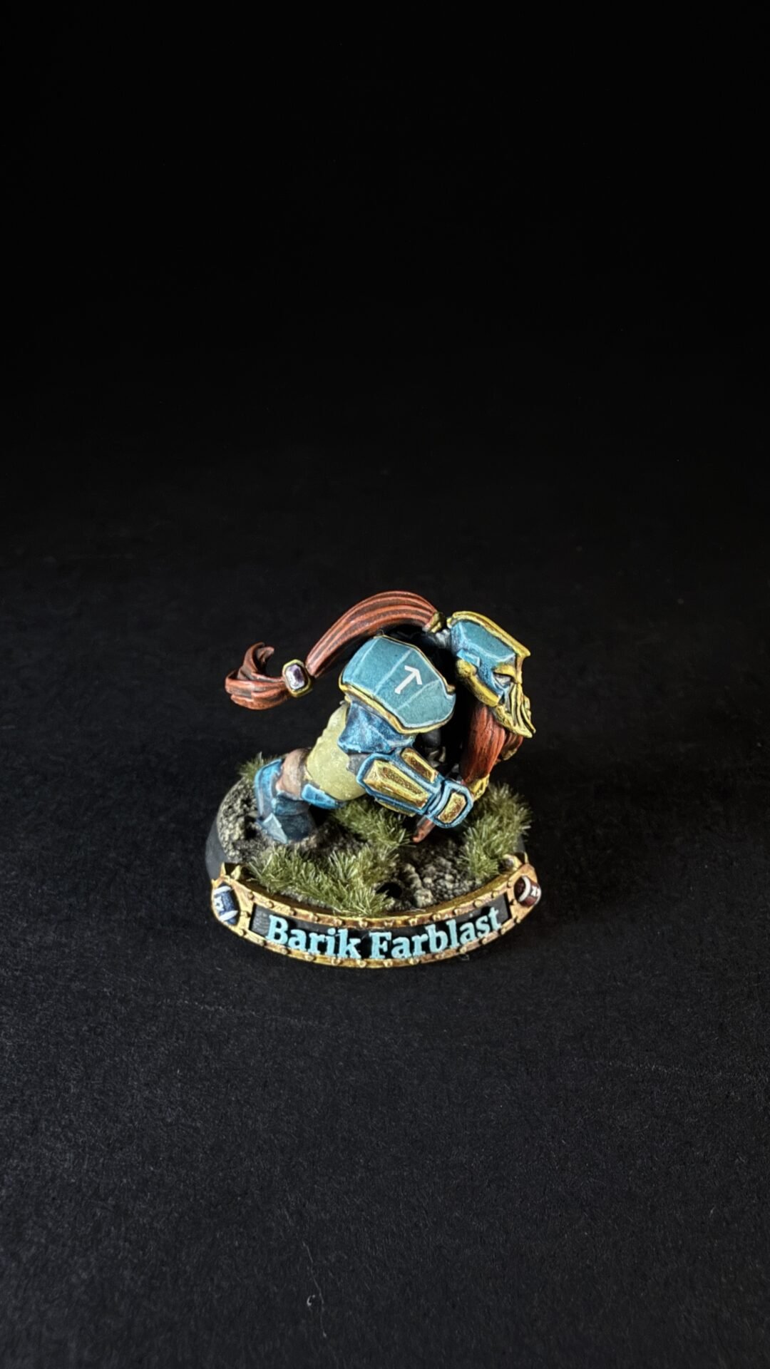 Tabletop fantasy miniature of Barik Farblast, a dwarf in teal armor with a red beard on a grassy base with a 'Barik Farblast' banner.