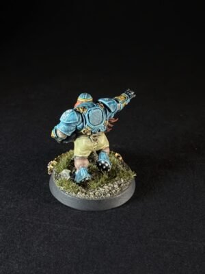 Blue-armored fantasy miniature sprinting on a grassy base, viewed from behind.