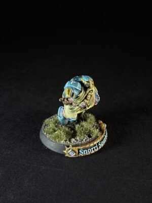 Painted miniature of a blue-and-yellow armored figure leaning forward with one arm extended, standing on a grassy diorama base labeled 'Snorri S...'