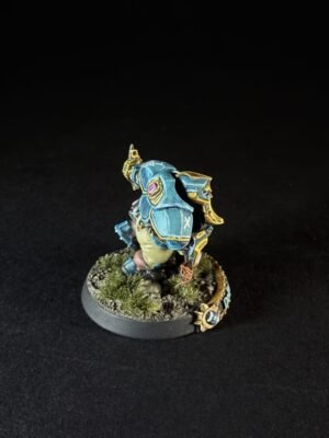 Painted blue armored miniature standing on a grassy diorama base.