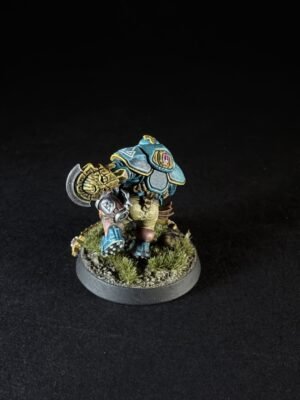 Painted fantasy dwarf warrior miniature in teal armor with gold trim, holding a large hammer, on a grassy round base.
