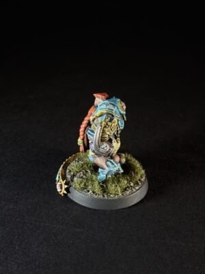 Painted fantasy miniature: a heavily armored figure in teal-blue armor on a grassy round base, posed as if advancing.