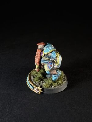 Colorfully painted fantasy miniature: a blue-armored warrior with a red left arm, standing on a grassy, textured base.