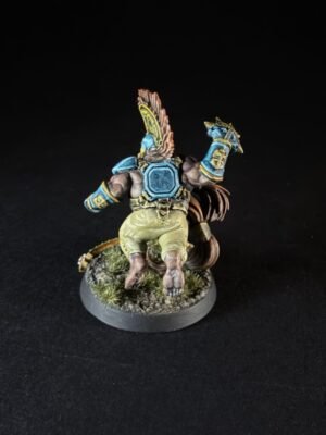 Back view of a fantasy miniature rider in blue armor on a beast, standing on a grassy base.