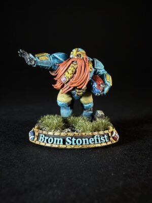 Miniature dwarf warrior in blue armor with a long orange beard, standing on a grassy base with a 'Brom Stonefist' name banner on the base