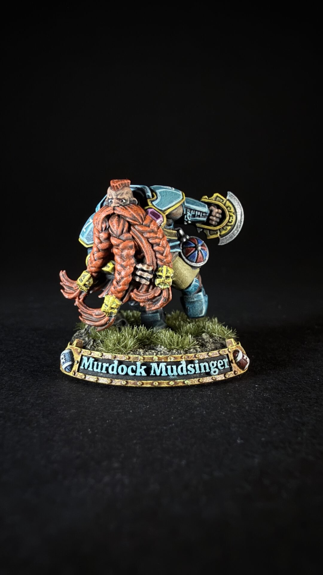Miniature of a burly dwarf with an orange braided beard, paired with a blue-armored companion; base reads 'Murdock Mudsinger'.