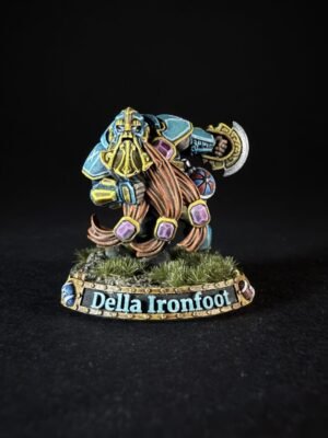 Painted fantasy dwarf miniature in blue armor with a long golden beard, wielding a hammer, on a grassy base labeled 'Della Ironfoot'.