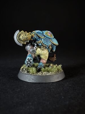 Painted fantasy dwarf miniature in blue armor with a large ornate hammer, standing on a grassy battlefield base.