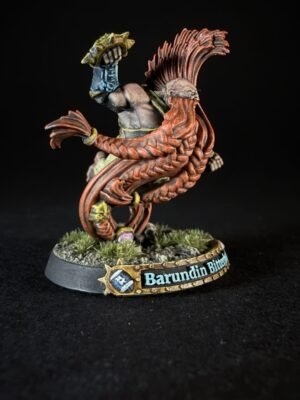 Painted fantasy miniature: a muscular figure with a red spiked mane and long braided cloak, raised fist, standing on a rocky base with 'Barundin Bitter' on the base plaque