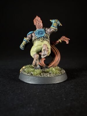 Back view of a fantasy miniature: armored figure sprinting with a blue chest plate, teal gauntlets, and a red energy trail behind, on a grassy base.