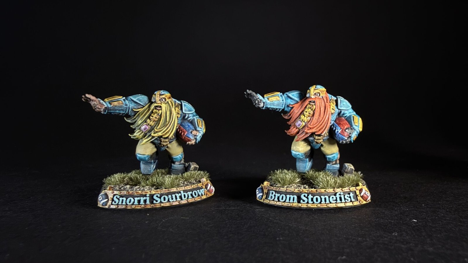 Two blue-armored dwarf miniatures with long beards stand on grassy bases, bases labeled Snorri Sourbrow and Brom Stonefist.