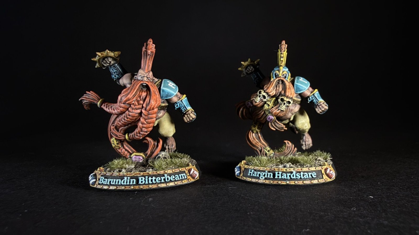 Two painted dwarf miniatures on grassy bases, name plaques read 'Barundin Bitterbeam' and 'Hargin Hardstare'.