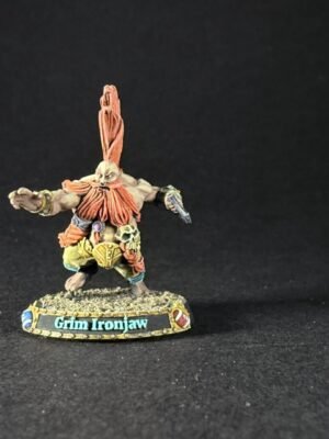 Painted fantasy miniature of Grim Ironjaw, a muscular dwarf with an orange crest and beard, standing with arms extended on a textured base.
