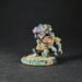 Miniature fantasy warrior figure, colorful armor, standing on rocky base with a banner reading Barik Farblast