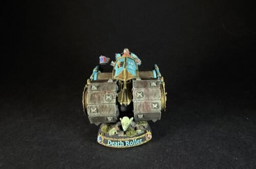 Front view of a painted Death Roller miniature war machine with teal cockpit, armored wheels, and goblin crew on a round base.