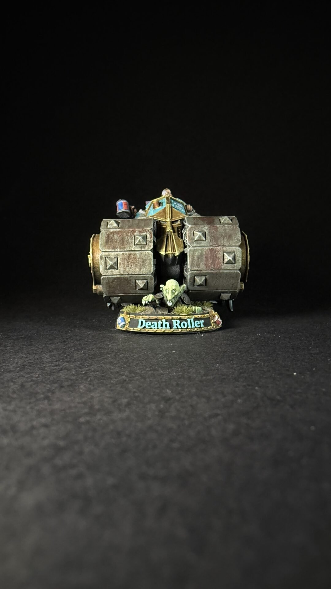 Miniature model of a Death Roller war machine with a goblin crew, on a grassy base labeled 'Death Roller' against a black background.