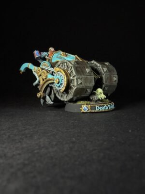 Painted Warhammer model: turquoise and gold armored tank with large tread wheels, a small goblin-like pilot on top, set on a round base with 'Death Roll' lettering and tufts of grass.