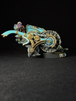 A turquoise and gold fantasy chariot miniature with a rider, ornate clockwork wheels, and mechanical blades on a black backdrop.