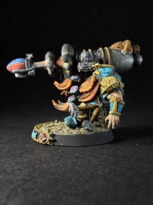 IMG_1125 Painted miniature of a horned dwarf/warrior in blue and gold armor, wielding a large hammer with a ram-like siege device on its back, standing on a textured base.