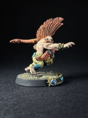 Winged humanoid miniature sprinting forward with orange feathered wings, wearing rugged armor on a textured diorama base.