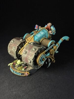 Painted Warhammer Death Roller miniature: teal and gold vehicle with a dwarf driver on a grassy diorama base, labeled Death Roller on the base banner.