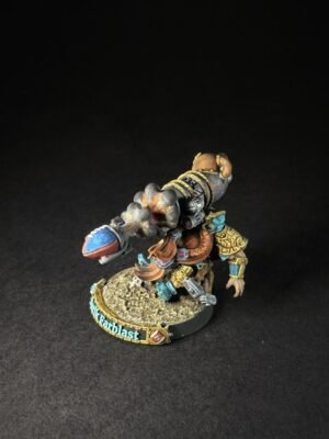 IMG_1150 Painted tabletop miniature of a armored warrior with a teal and gold outfit, carrying a large lizard-like creature strapped to his back on a rocky base.
