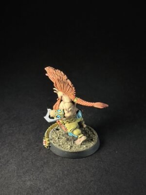 Small fantasy warrior miniature with an orange feathered headdress wielding a small axe, standing on a rocky base.