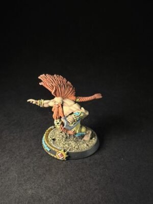 Painted fantasy miniature of a winged warrior with red hair leaping forward on a textured base.