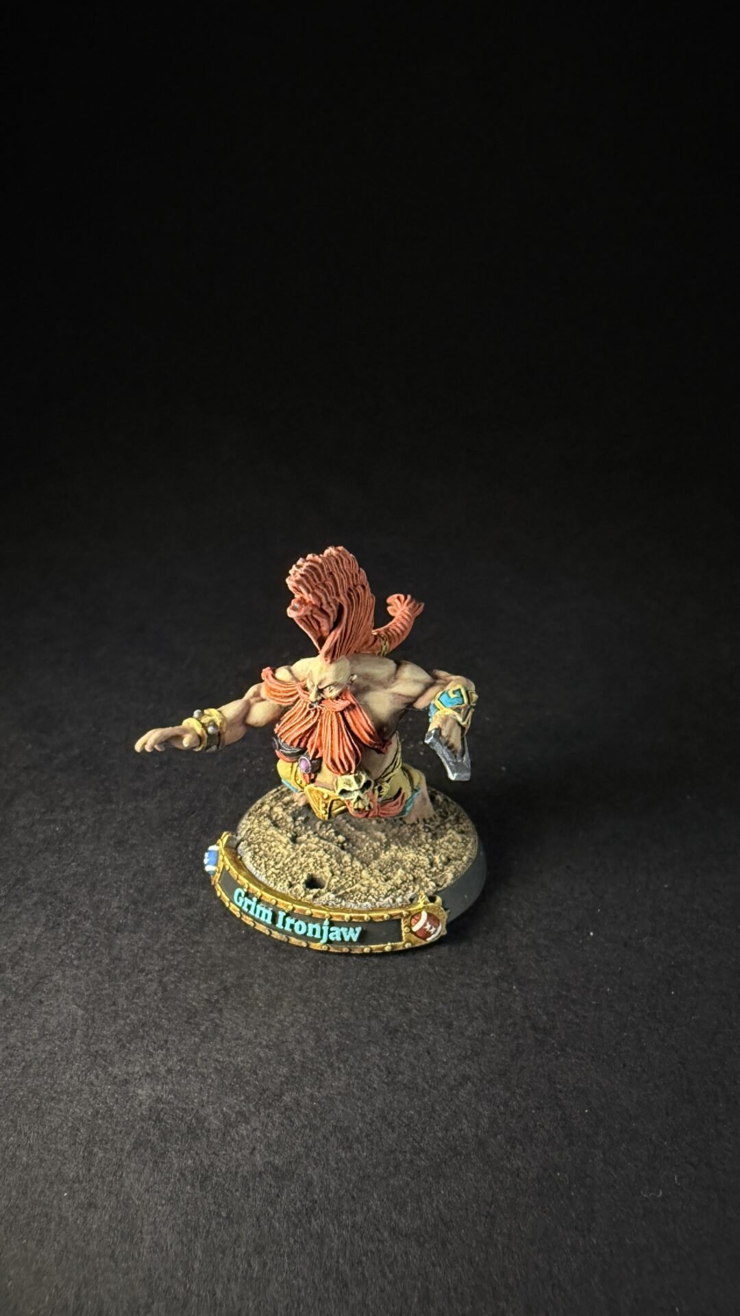 Tabletop miniature of a muscular warrior with orange hair, standing on a rocky base; base reads 'Glim Ironjaw'.