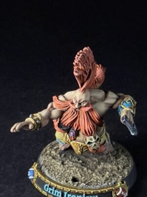 Tabletop miniature of a muscular gray-skinned orc with a red mane, ornate armor, and raised fists standing on a rocky base, with a 'Grim Ironjaw' banner at the base.