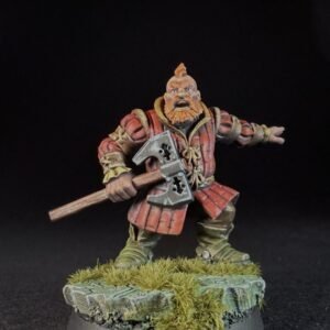 Miniature dwarf warrior with orange beard in red armor, holding a double-headed axe, standing on a grassy base.