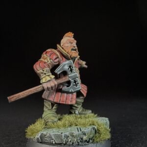 Miniature dwarf warrior in red armor, gripping a double-headed axe, standing on a grassy rocky base.