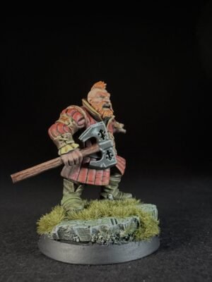 IMG_1492 Miniature dwarf warrior in red armor, gripping a double-headed axe, standing on a grassy rocky base.
