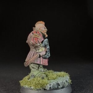 Painted fantasy miniature of a bearded warrior in red armor, carrying a shield and club, standing on a mossy rocky base