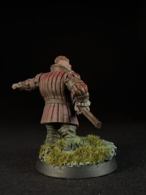 IMG_1494 Back view of a miniature medieval knight in red segmented armor, standing on a grassy base with a sword in hand against a dark background, seen from behind.