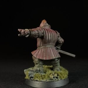 Back view of a medieval knight miniature in red armor, with right arm extended as if pointing or gesturing, sword at the hip, standing on a grassy base.