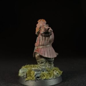 Painted miniature of a medieval knight in pink armor standing on a grassy base, facing forward with a pointed gesture.
